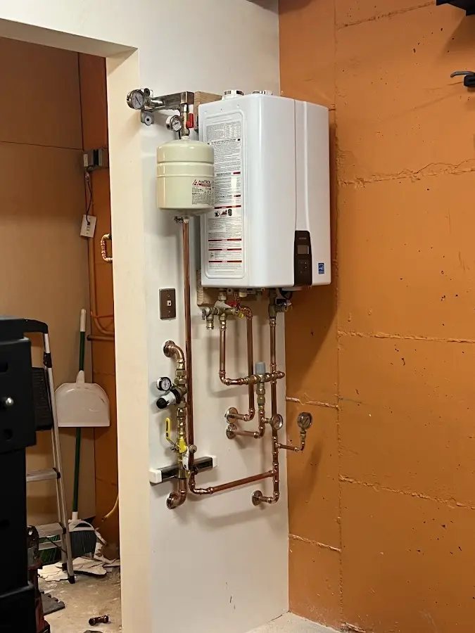 Plumbing technician inspecting water heater connections in Mogadore